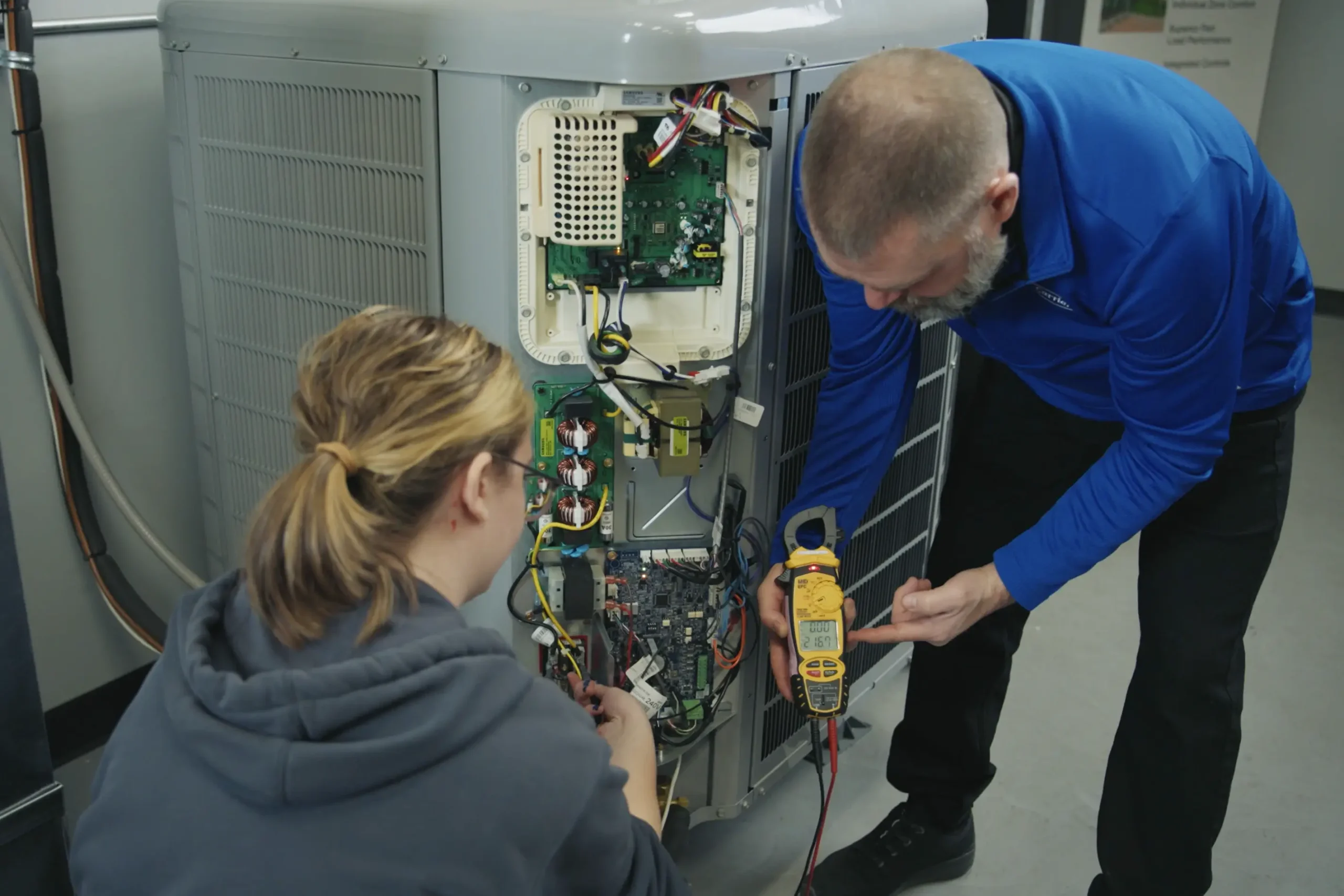 PennHPP specialists conducting a technical inspection and electrical diagnostics on a high-performance HVAC unit.